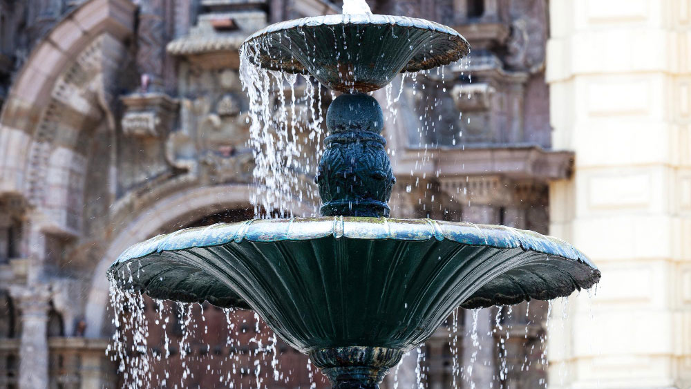Water cascading down the tiers of a classic fountain, exemplifying water features' electricity use.
