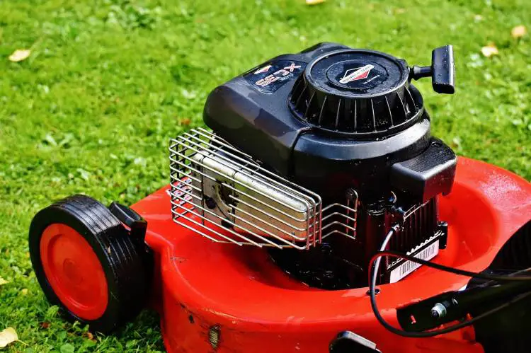 Close-up of a red lawnmower with a black motor, showcasing possible high revving issue.