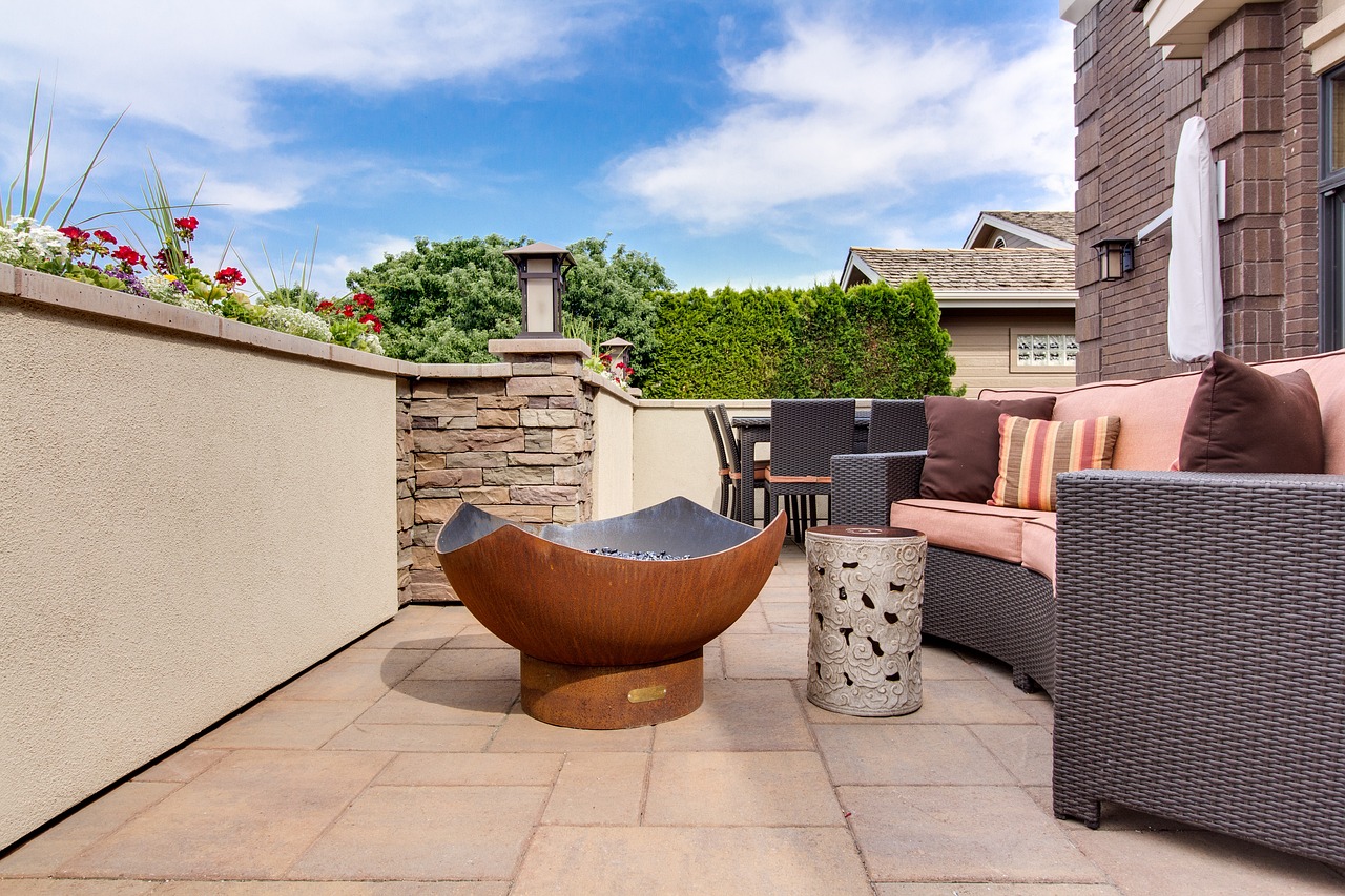 Modern patio setup with rattan seating and a central fire bowl, well-maintained without patio turning black.