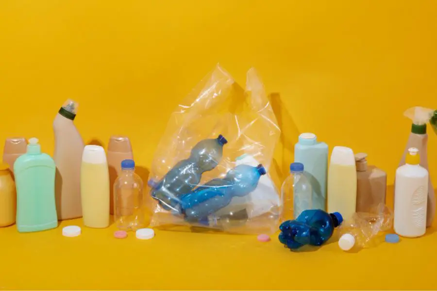 Assorted plastic containers on yellow background, recyclable materials.