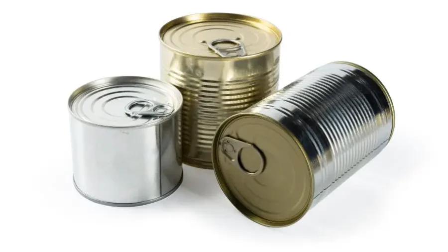 Three metal food cans of varying sizes on a white surface.