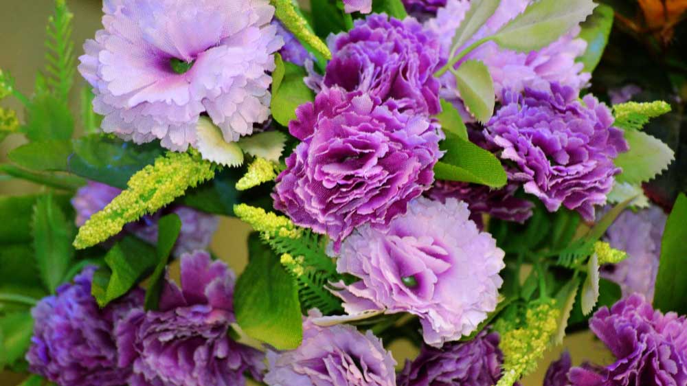 A bouquet of artificial lavender and purple flowers with delicate greenery, displaying vibrant colors and textures.