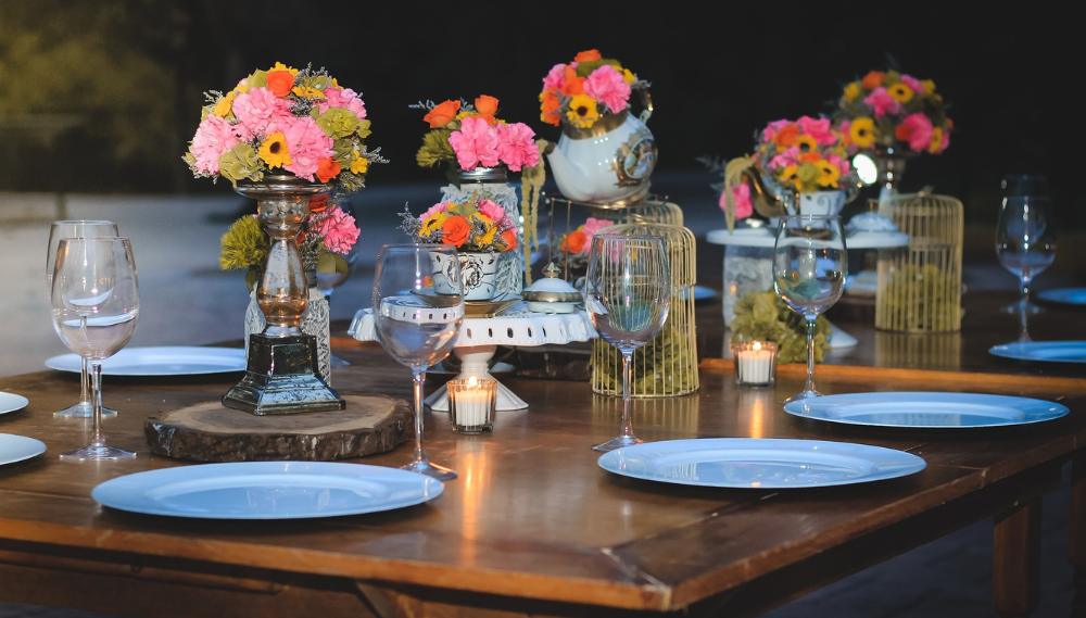 Evening outdoor table with flowers, centerpieces, candlelight, crystal stemware.